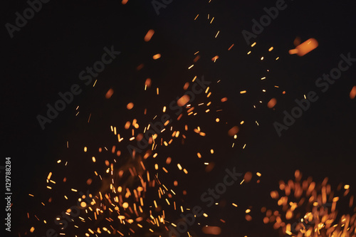 Leinwand Poster sparks from bonfire over dark night environment, shallow focus