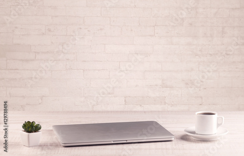 Office desk closeup with white brick wall