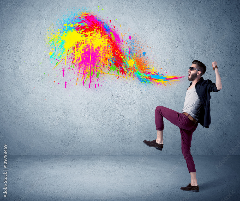 Fototapeta premium Hipster guy shouting colorful paint on wall