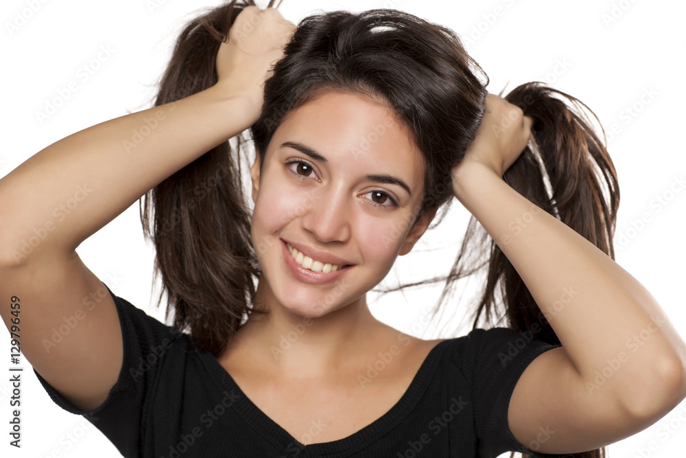portrait of happy girl who holds her hair in two tails portrait of happy girl who holds her hair in two tails