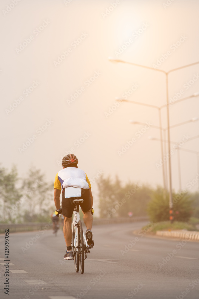 Asian young man ride a bike on road in morning.