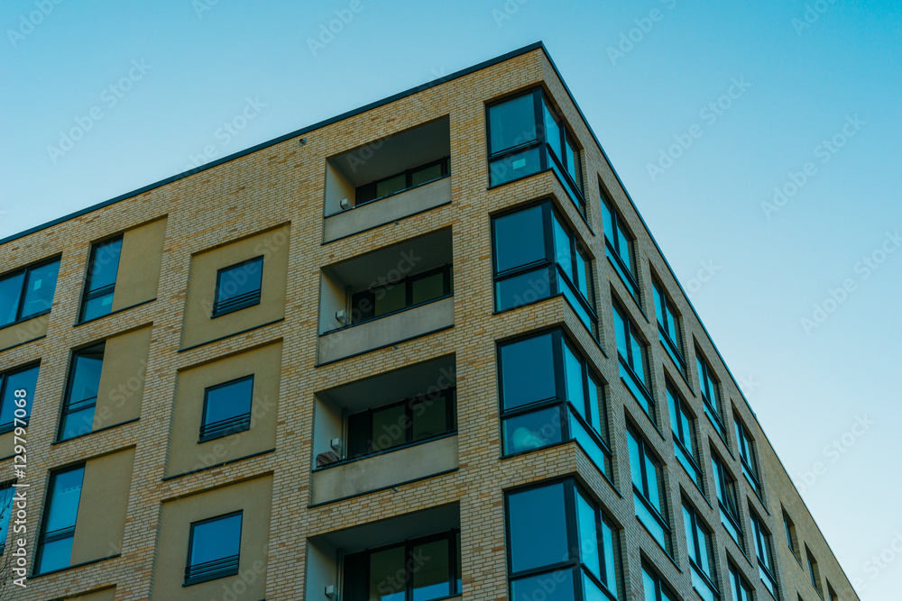 brick building with blue windows and big balcony