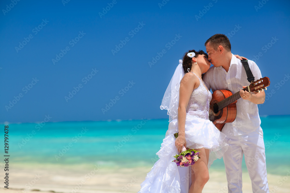 groom performed the song for the bride on a guitar at the beach groom performed the song for the bride on a guitar at the beach