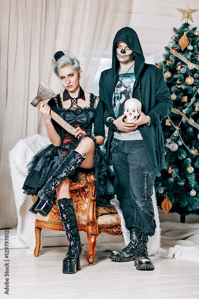 Young gothic couple posing near a Christmas tree. Goth style male model  with skull and Goth girl with axe in Christmas decorations. Stock Photo |  Adobe Stock