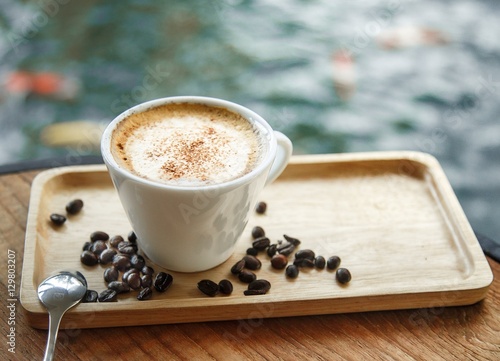 Cup of coffee on the table. A wooden tray. photo