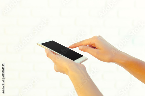 Woman with modern mobile phone in hands