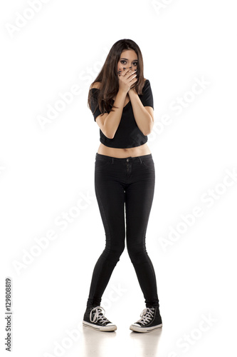 young girl in black pants, shirt and sneakers on a white background