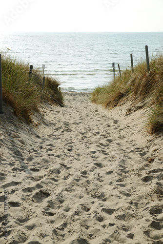Sun set over footpath leading to sea through sand dunes, Island of Ruegen, Germany