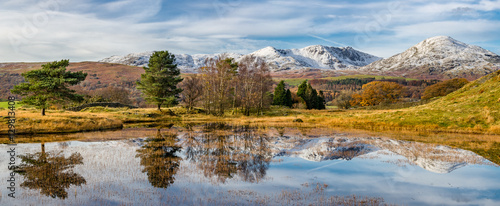 Cumbrian snowcapped mountains with clear reflections in Kelly Hall Tarn on a Autumnal afternoon.