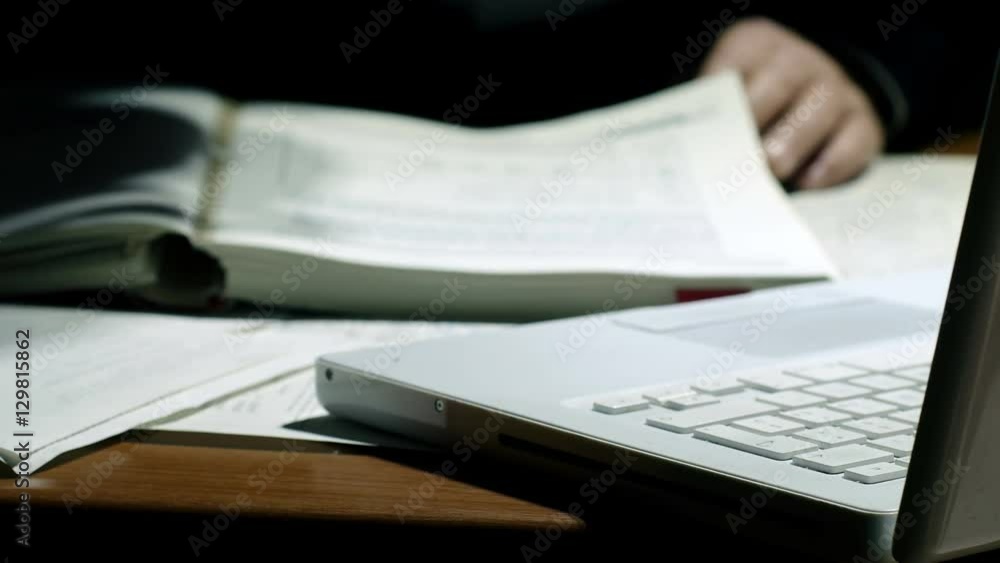 man at work in the night with some paper and notebook man at work in the night with some paper and notebook