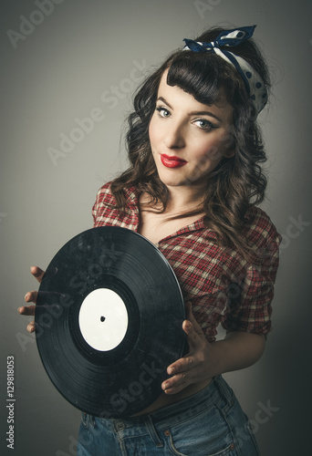 Cute retro pin up girl holding a vinyl record