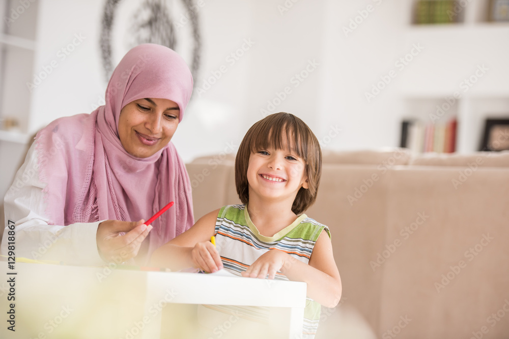 Arabic mother with little son learning in living room Arabic mother with little son learning in living room