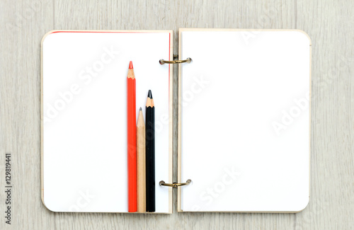 Wallpaper Mural Opened blank notepad with colorful pencils on wooden table Torontodigital.ca