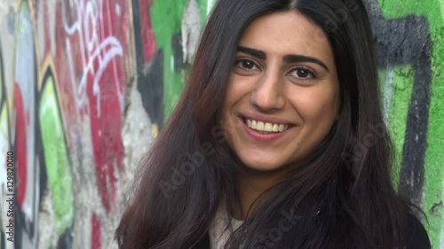 Beautiful young multiracial female in city, smile happy face portrait.