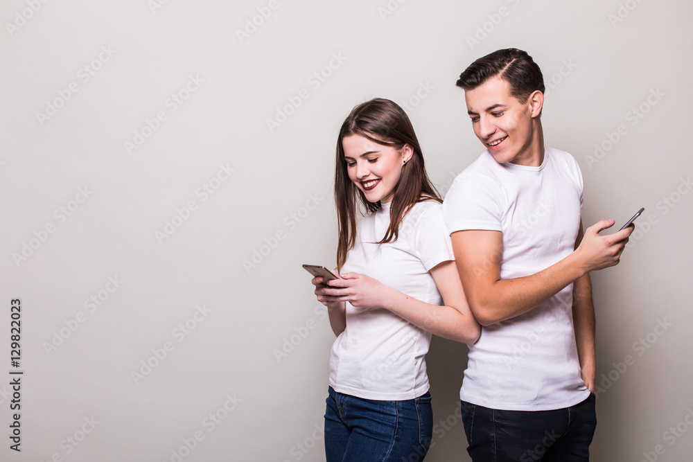 couple in love ignoring each other with telephone. Caucasian couple against white background. couple in love ignoring each other with telephone. Caucasian couple against white background.