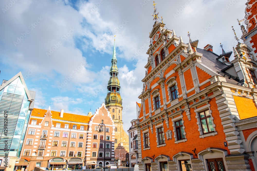 Obraz premium View on the central square with famous houses of Blackheads and cathedral tower in Riga city, Latvia