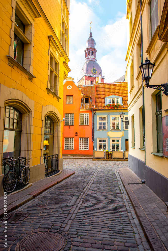 Fototapeta premium Street view with bell tower of Dome church in the old town of Riga city, Latvia