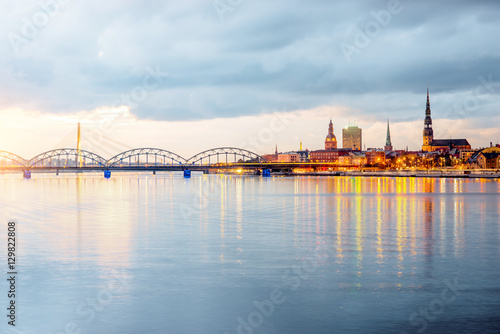 Night view on the illuminated riverside with reflection on the river in Riga, Latvia