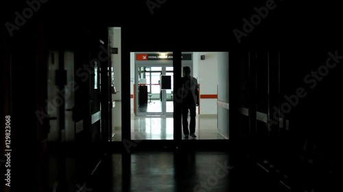 doctor walks hospital corridor, hallway, during night duty