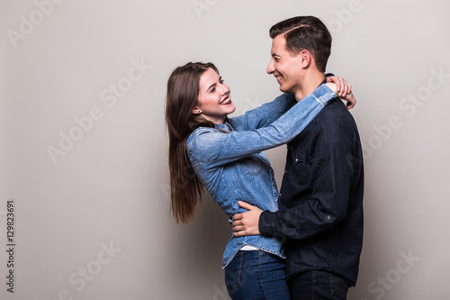 Couple hugging on grey background
