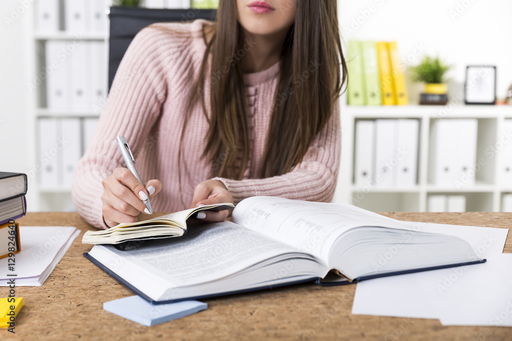 Woman working with a book and writing