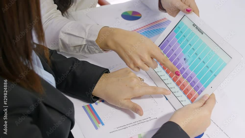 businesswomen discussing on financial data using a tablet computer
