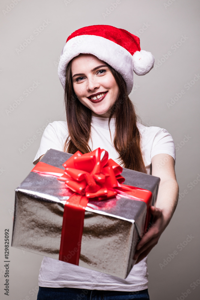 Christmas Woman share you Gift Box. Beautiful Brunette Girl in Santa Hat isolated. Christmas Woman share you Gift Box. Beautiful Brunette Girl in Santa Hat isolated.