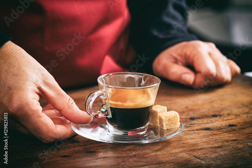 Waiter holding a cup of espresso