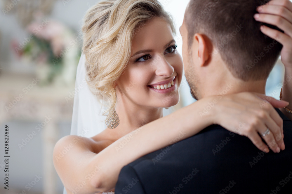 Embrace on wedding day. Beautiful bride embracing groom in the neck