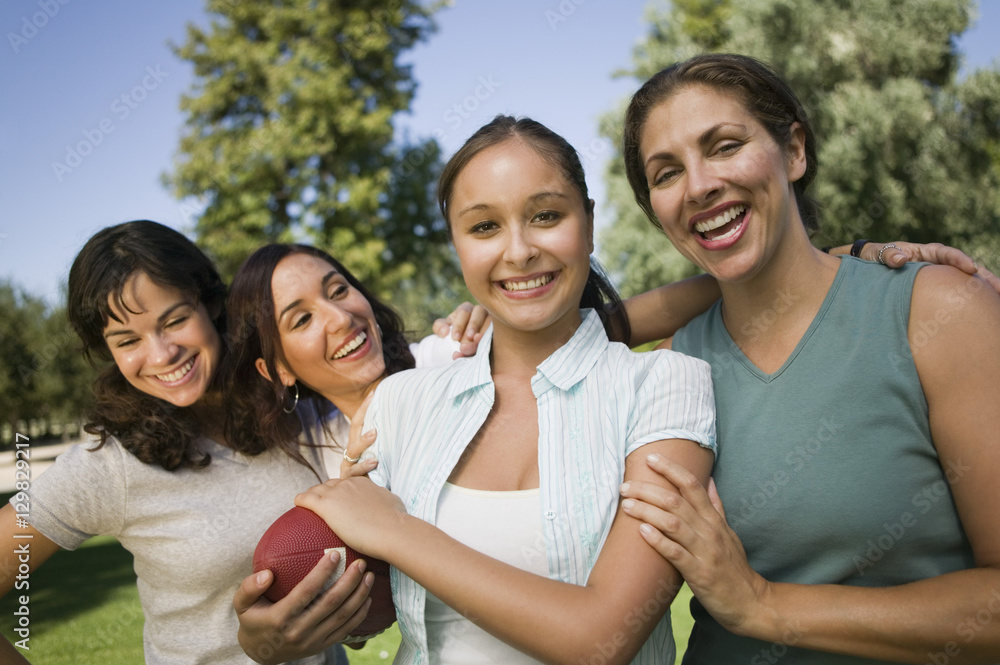 Four women playing football outdoors. Four women playing football outdoors.