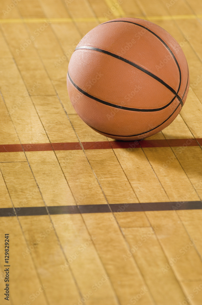 Close-up of a basketball on wooden floor Close-up of a basketball on wooden floor
