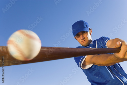 Photography Baseball player hitting the ball with a bat against clear blue sky