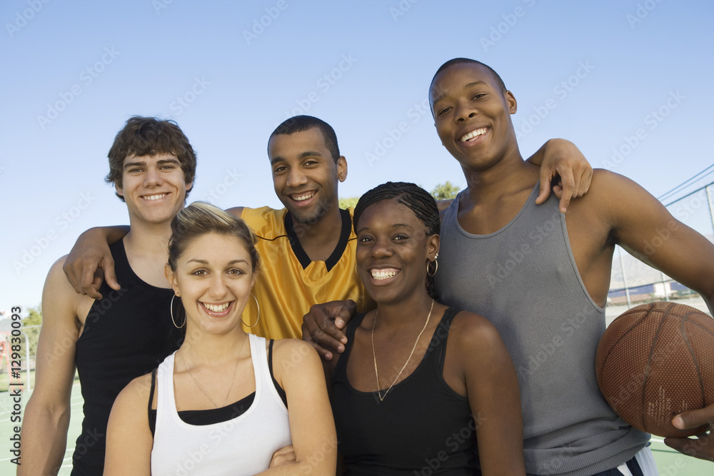 Group portrait of multiracial friends with basketball
