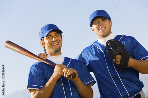 Photography Portrait of happy young baseball players standing against clear sky