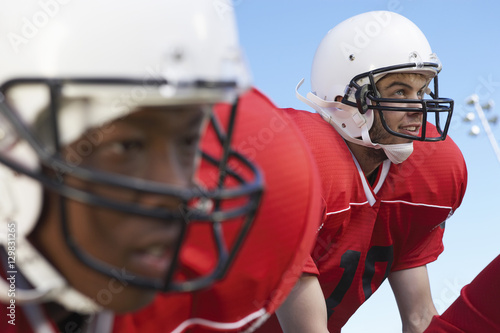 Tableau sur toile Closeup of quarterback waiting for snap against clear sky