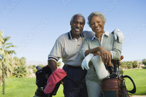 Portrait of happy senior couple in golf course smiling