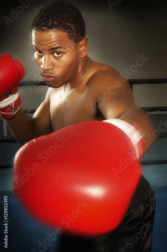 Portrait of a young aggressive African American male boxer punching