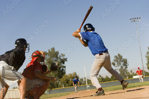 Baseball striker ready for a shot with keeper and umpire in position
