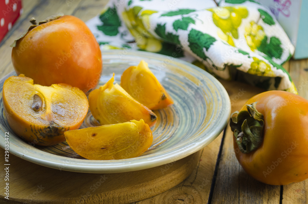 ripe persimmon on a plate ripe persimmon on a plate