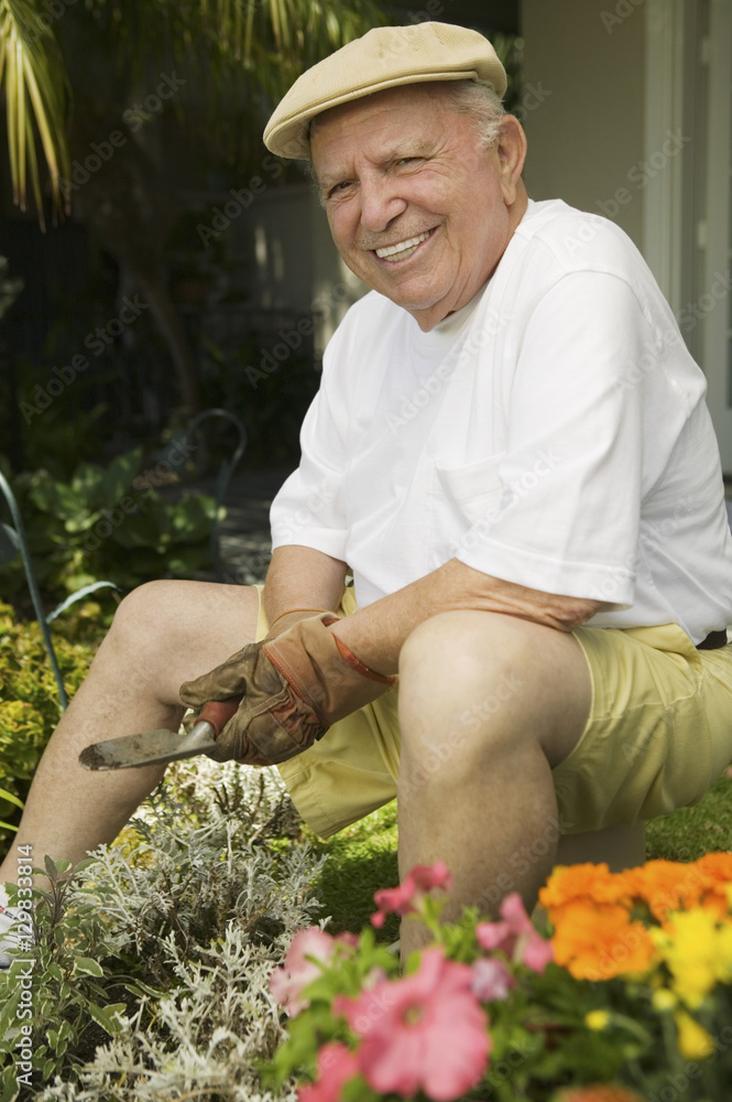 Portrait of a happy senior man working in his garden