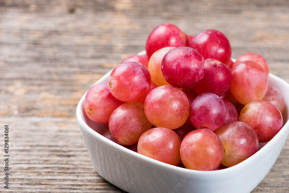 Grapes in bowl on the wooden table in natural light Grapes in bowl on the wooden table in natural light