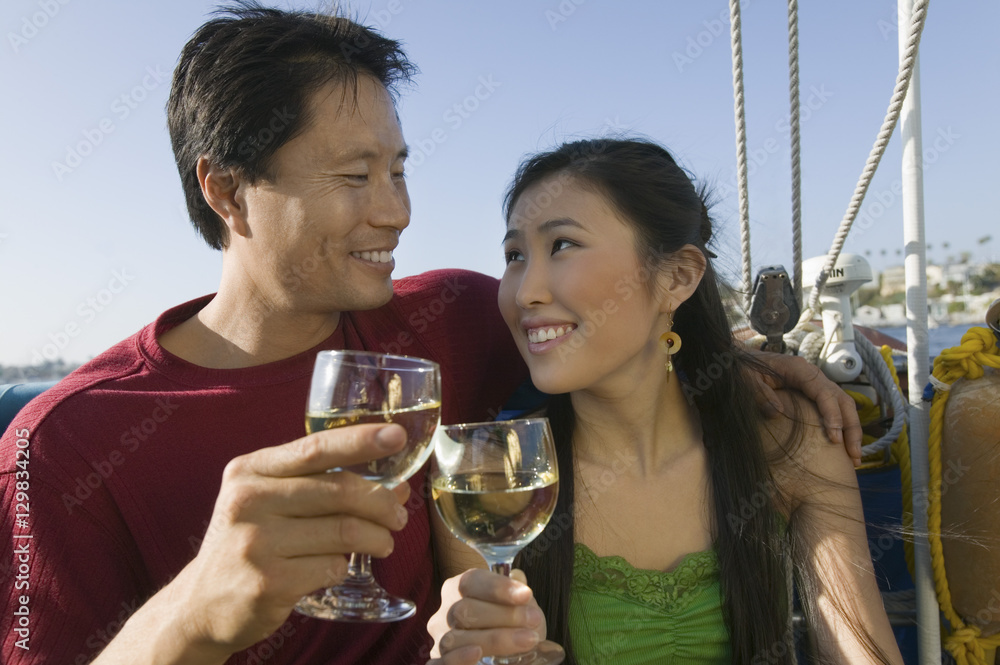 Smiling couple toasting wine glasses on the boat Smiling couple toasting wine glasses on the boat