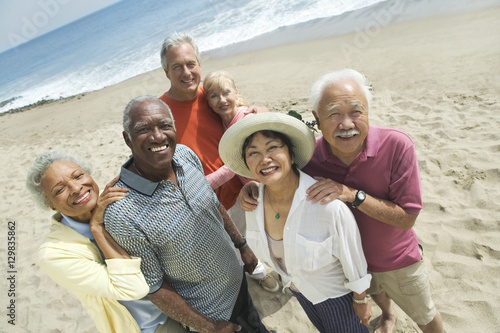 Group portrait of happy multiethnic couples smiling on the beach photo