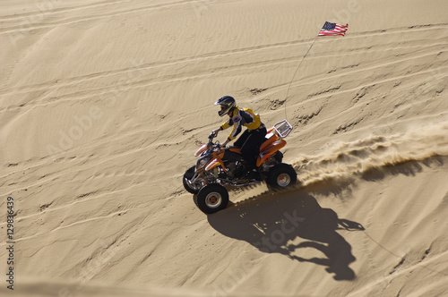High angle view of a quad racer riding over sand dune