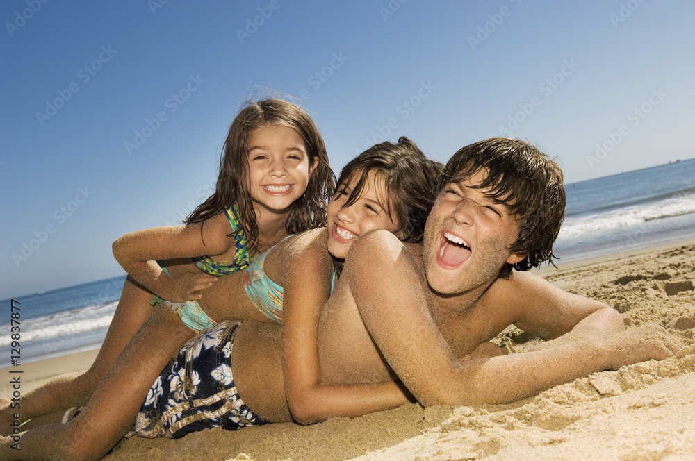 Brother and sisters having fun at beach on a sunny day Brother and sisters having fun at beach on a sunny day