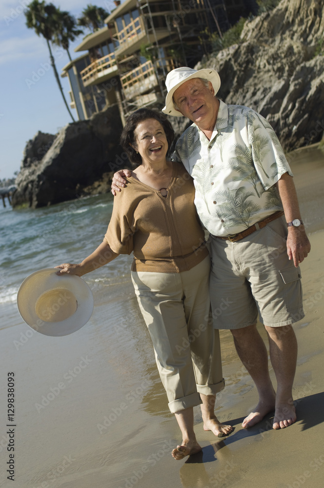 Portrait of happy senior couple standing at beach