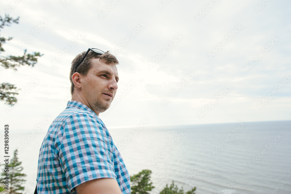 man sitting on the wooden stairs in park and smiling