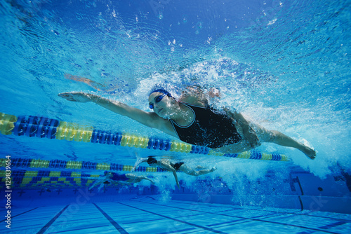 фотографія Female participants gushing through water in swimming competition