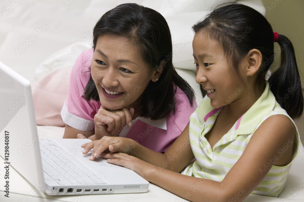 Mother and Daughter in living room Using Laptop Together Mother and Daughter in living room Using Laptop Together