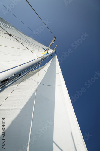 Low angle view of mast of the yacht against blue sky © moodboard